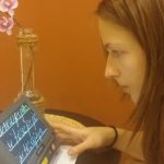 UAB „Masažo namai“ masažistė  Kristina J. naudojasi specialiu  planšetiniu kompiuteriu.
