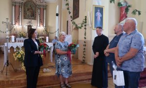 Kun. Mindaugą Martinaitį (centre) su dešimties metų klebonavimo sukaktimi sveikino seniūnė Judita Skystimienė, bendruomenės atstovai Regina Vansevičienė, Kęstutis Nikliauza. Birutės Nenėnienės nuotr.