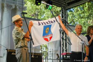 Švėkšnos seniūnas Alfonsas Šeputis (dešinėje) miestelio vėliavą įteikė alpinistui Broniui Venslovai / Šarūnės Nausėdaitės nuotr.