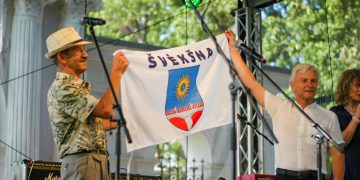 Švėkšnos seniūnas Alfonsas Šeputis (dešinėje) miestelio vėliavą įteikė alpinistui Broniui Venslovai / Šarūnės Nausėdaitės nuotr.